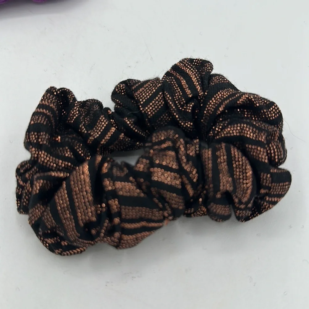 Hair scrunchies: one bat-shaped and one black/copper